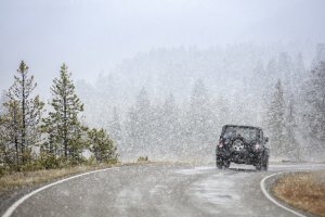 ein fahrendes Auto auf kurviger Straße im Schnee