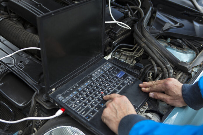 Laptop am Automotor zum Tunen des Autos