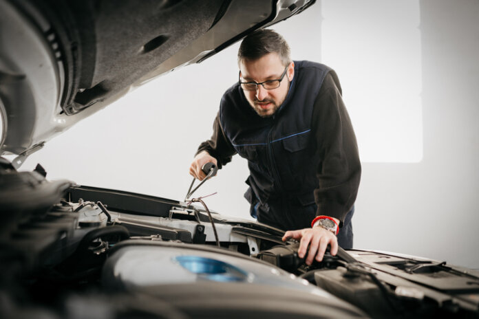 Kfz-Mechaniker, der am Kühler arbeitet