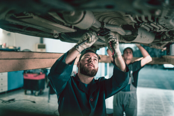 Mechaniker bei der Auspuff-Reparatur