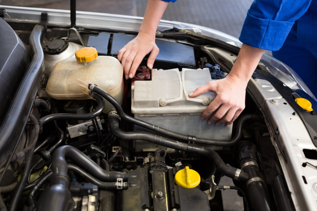 Mechaniker untersucht unter der Motorhaube eines Autos in der Reparaturwerkstatt