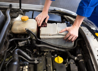 Mechaniker untersucht unter der Motorhaube eines Autos in der Reparaturwerkstatt